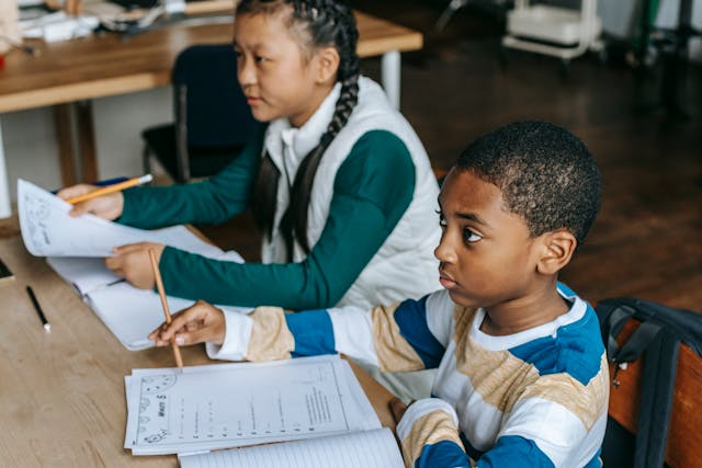 2 enfants assis à un bureau de classe