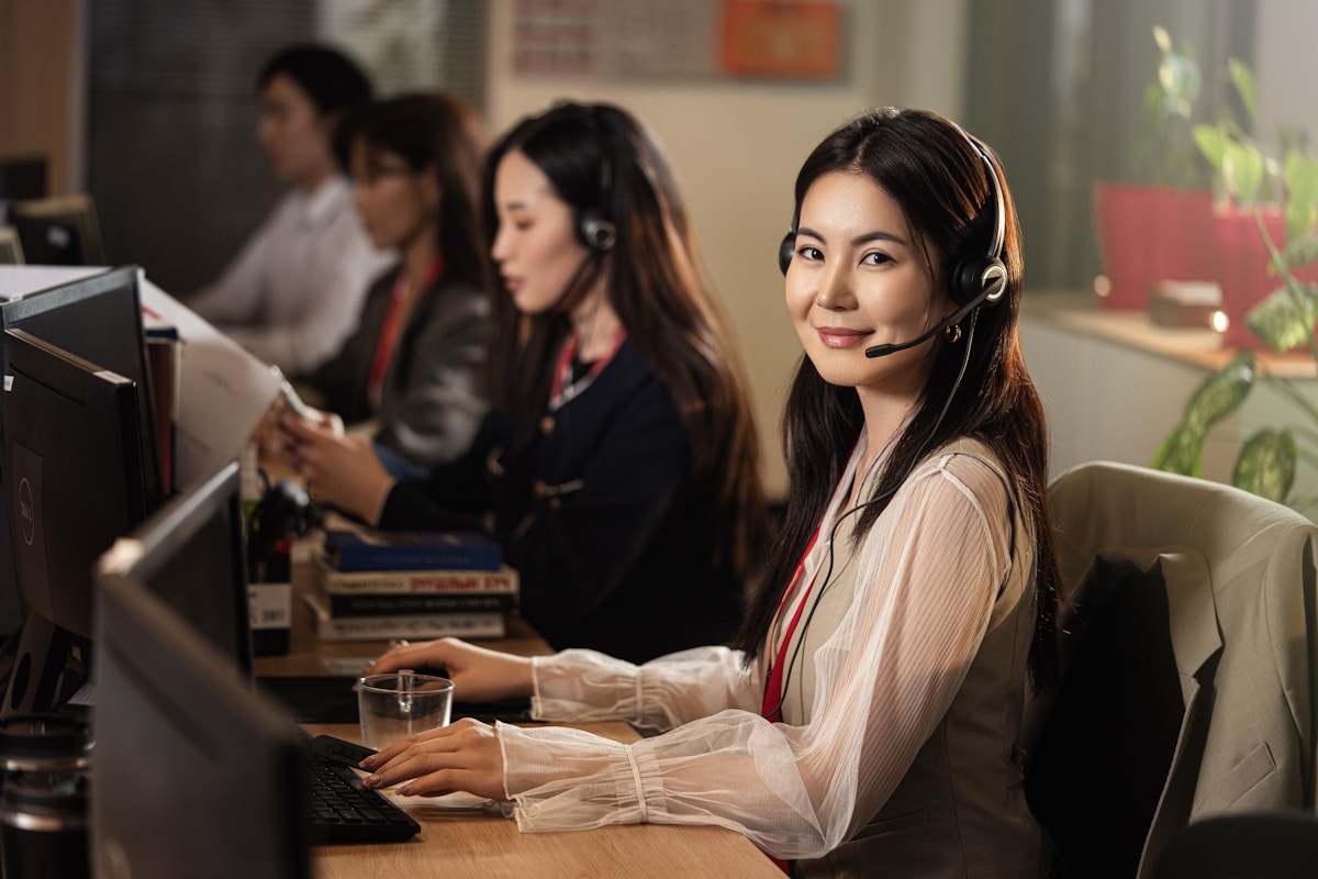 Smiling woman wearing headset for English phone conversations