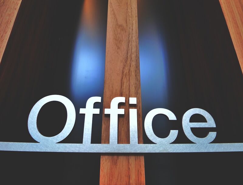 Professional typing business email in modern office environment