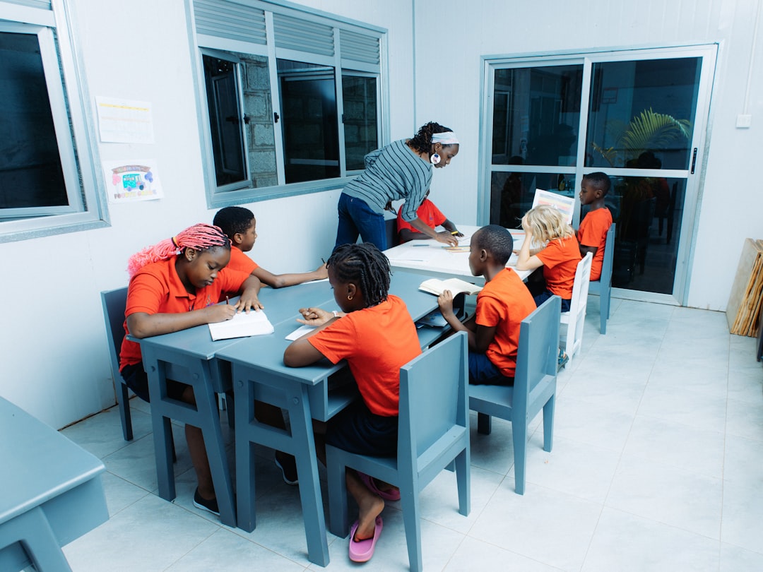 Teacher instructing elementary students at classroom tables