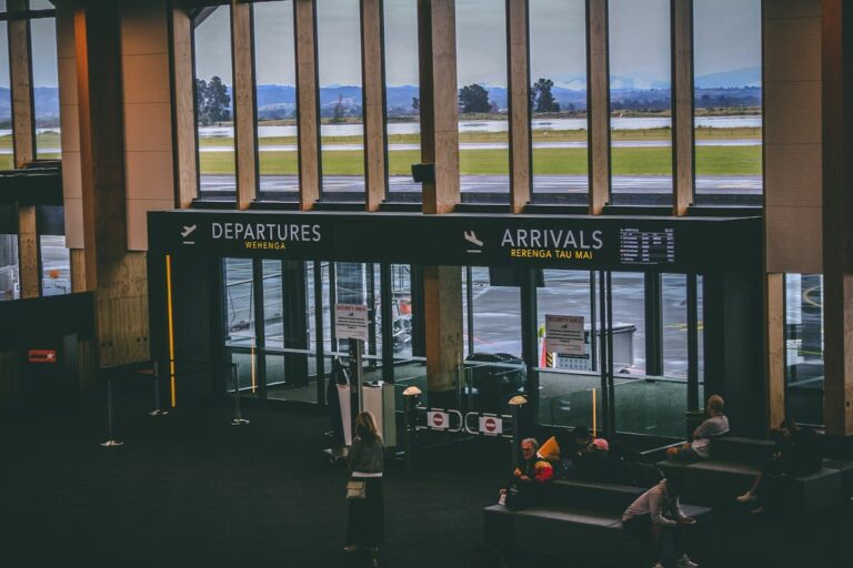 Busy airport terminal with departures and arrivals signs for travel English learners