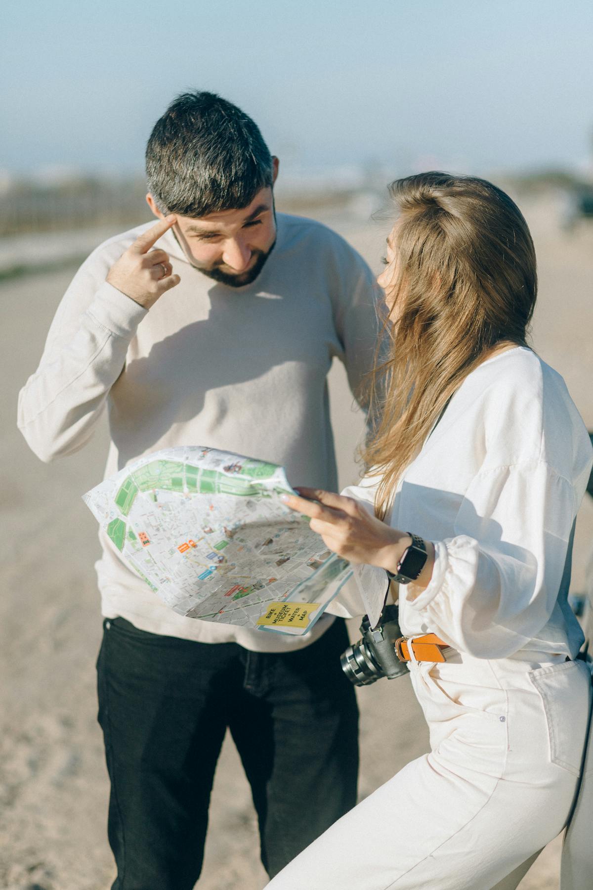 Couple studying a map outdoors asking for directions in English while traveling