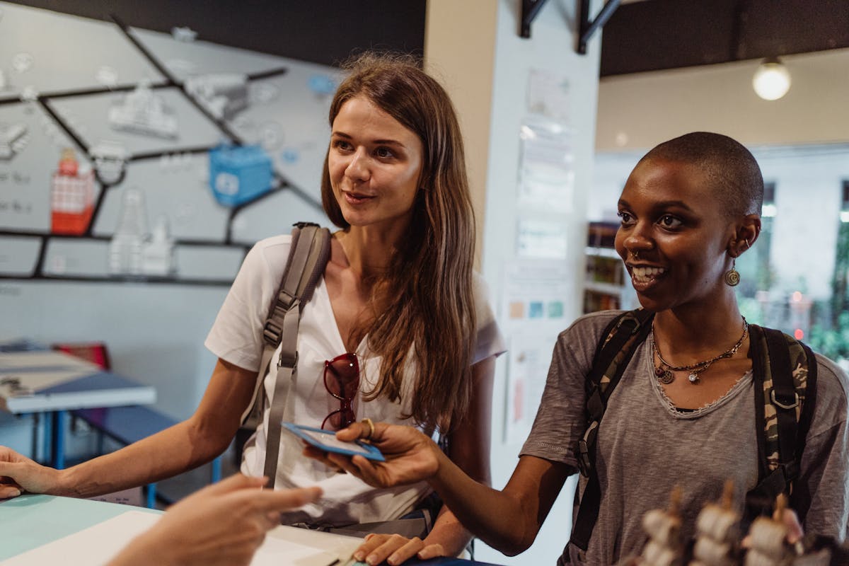 Tourists at hostel reception practicing English conversation during travel