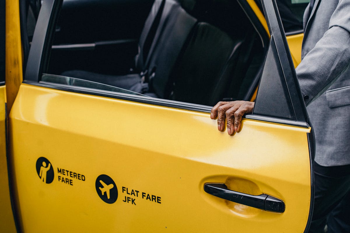 Person opening a yellow taxi door learning transportation English vocabulary