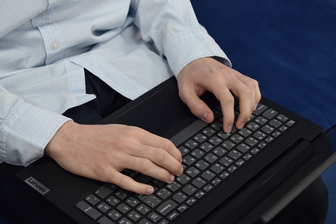Person typing 商業英文 business English writing on laptop keyboard