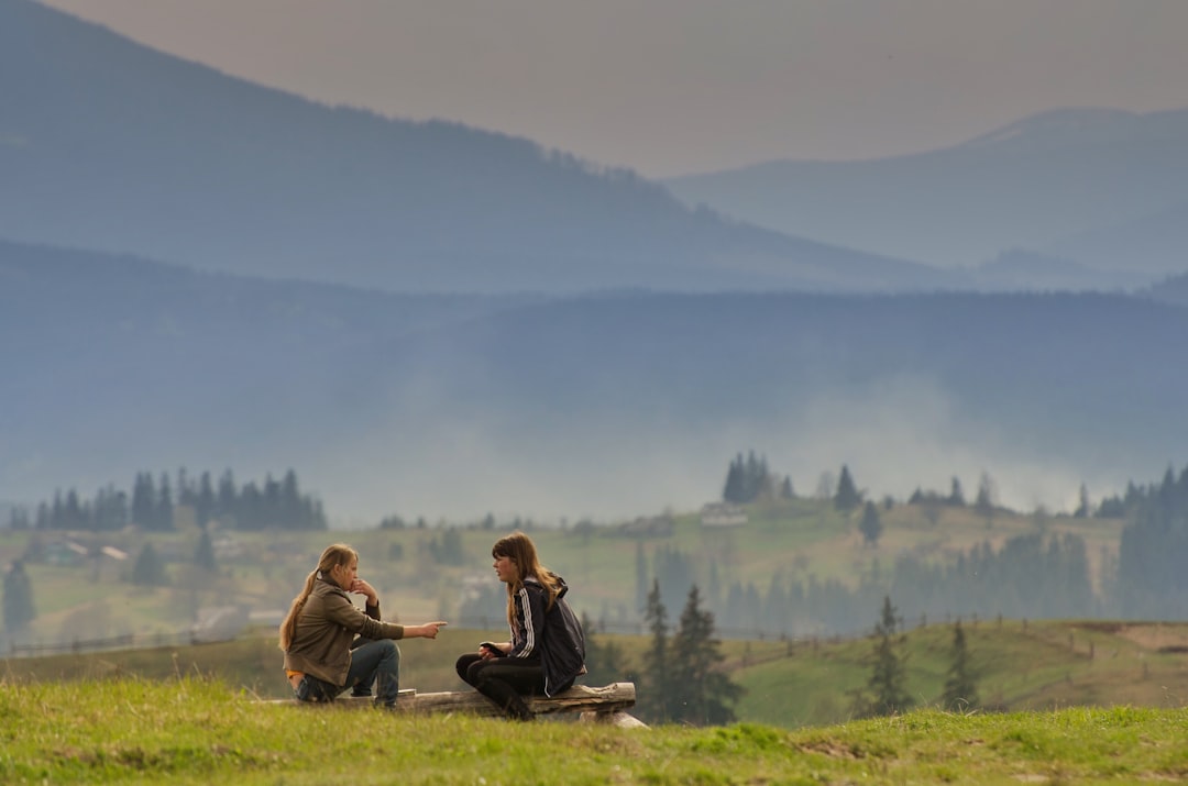 Two people having a conversation on a hillside, representing everyday English conversation practice