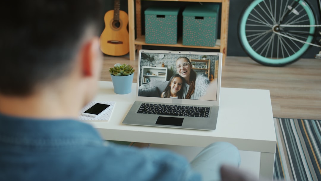 Family woman, man and little girl are making online video call using laptop at home, guy is talking to wife and daughter show
