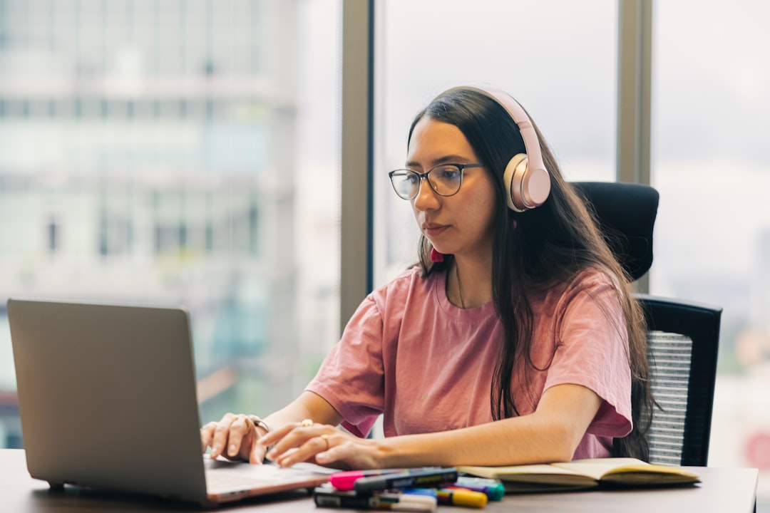 Woman wearing headphones working on a laptop