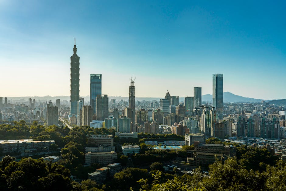 Stunning aerial shot of Taipei cityscape with the iconic Taipei 101 and clear blue sky.