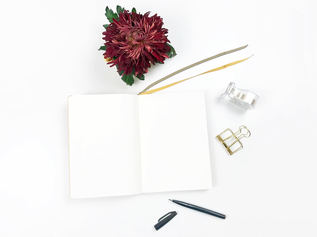 Notebook Flatlay with ChrysanthemumBright topview flatlay photography with blank notebook and crimson red chrysanthemum f