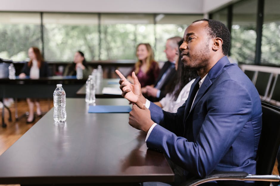 Professionals in a conference room engaged in discussion, showcasing diversity and teamwork.