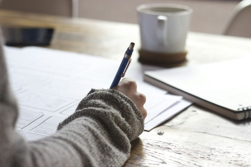 Writing an English self-introduction script in a notebook | 英文自我介紹練習