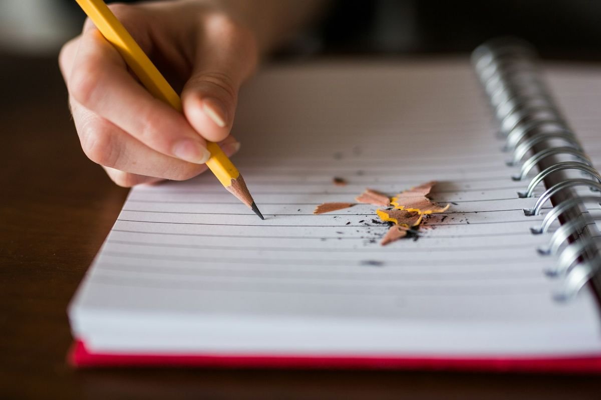 Past and future tense worksheets for ESL learners — pencil writing on notebook