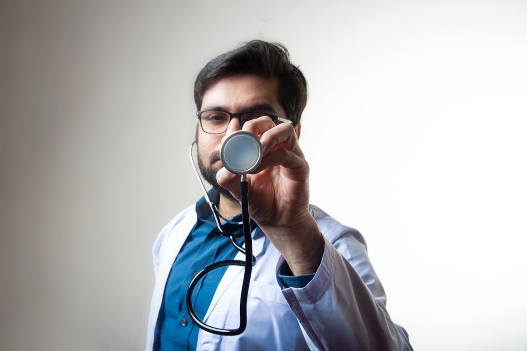 A doctor with stethoscope pointing in front covering face forward