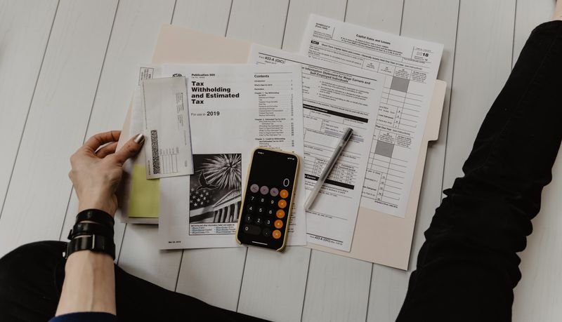 財務預算多益單字 — tax forms and calculator showing finance vocabulary