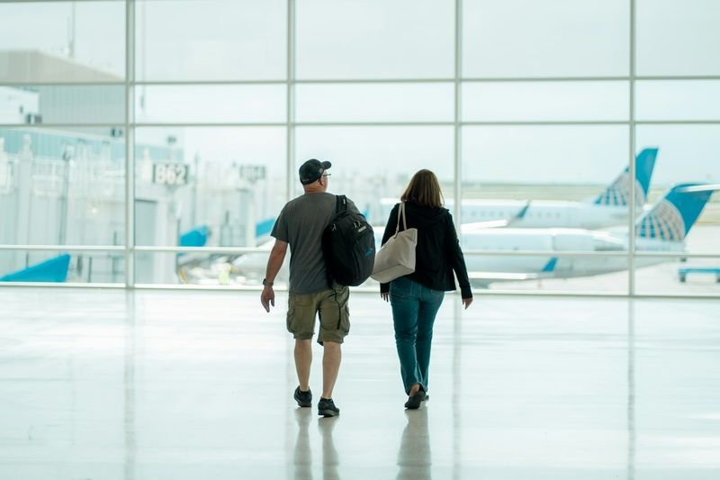 旅行多益單字 — travelers at an airport demonstrating TOEIC travel vocabulary