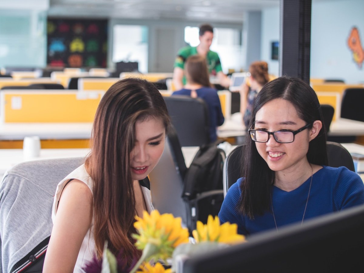 Coworkers practicing daily workplace English at office