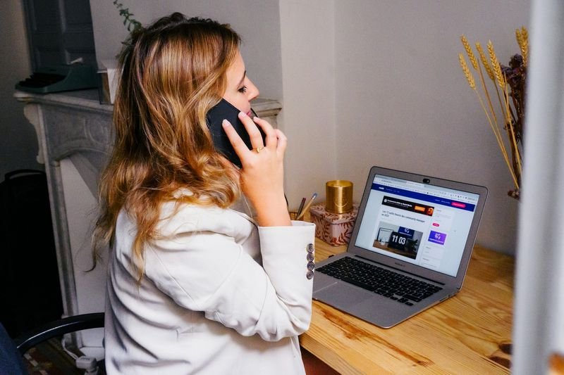 Taiwanese professional answering business phone in English at office desk
