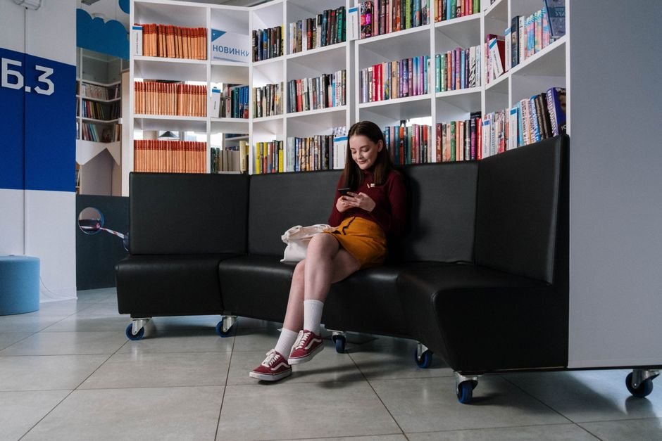 Teen reading an English novel in the library