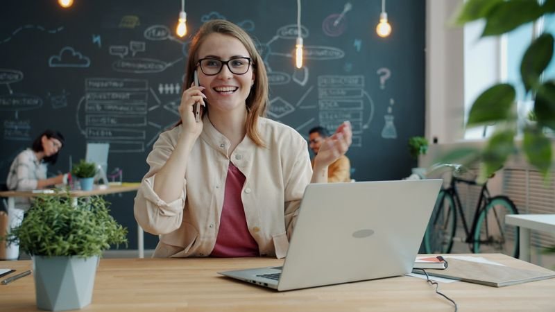 在現代辦公室自信用英文講電話的女性 woman confidently talking on the phone in English 電話英文對話