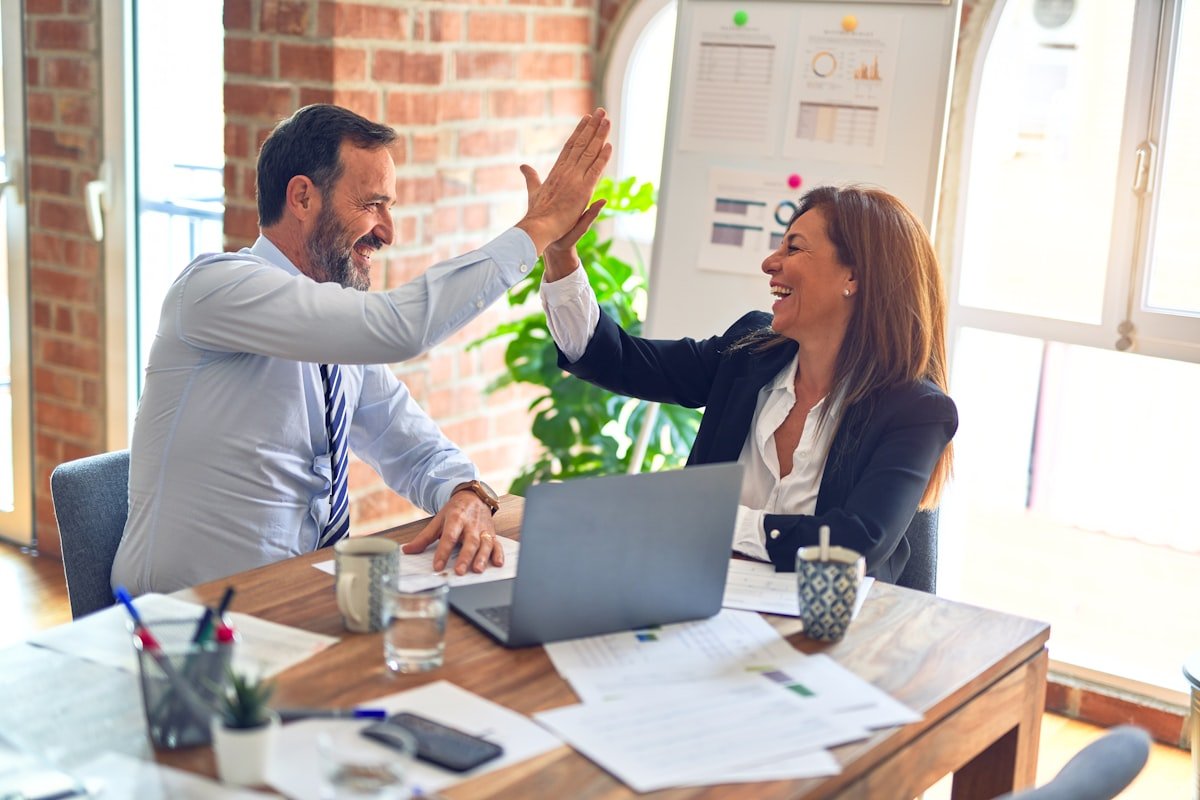 apology accepted celebration coworkers reconcile high five office