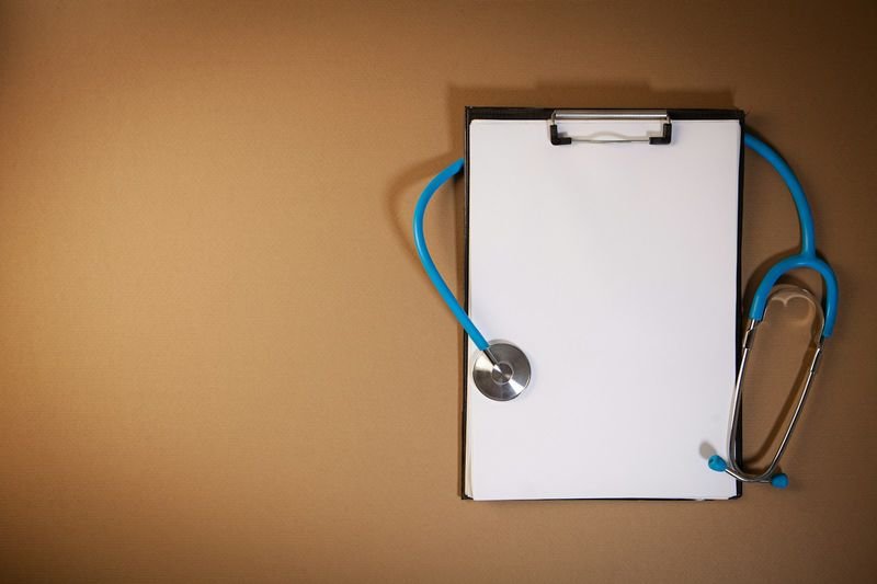 Doctor stethoscope and clipboard for medical appointment leave English