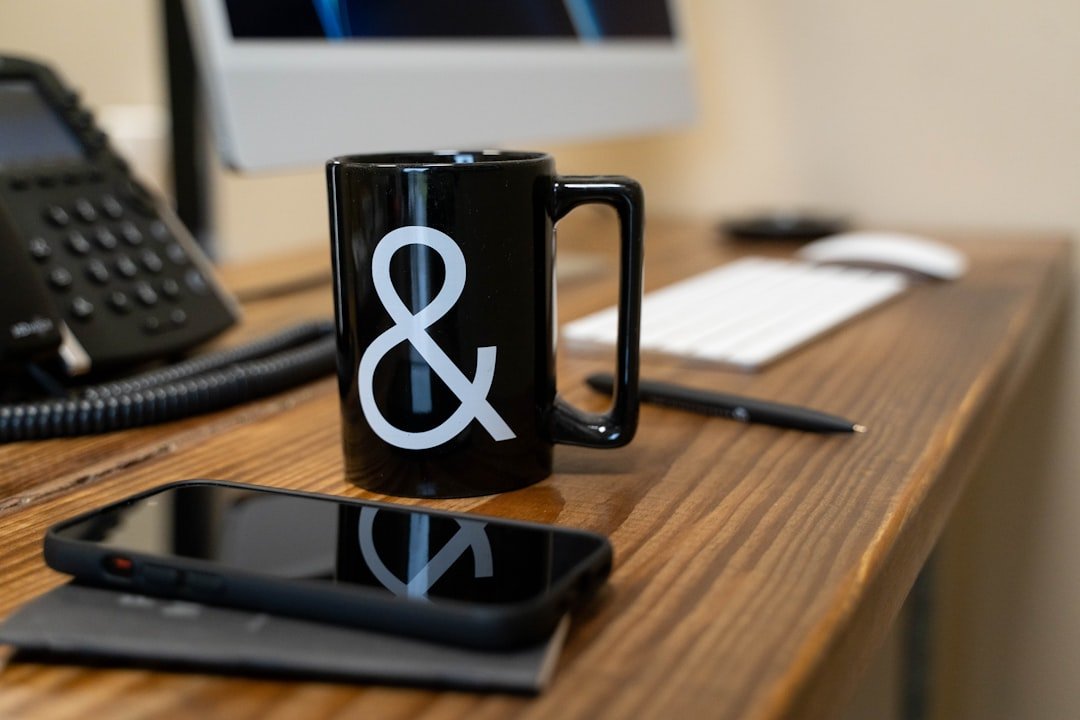 a black coffee mug sitting on top of a wooden desk