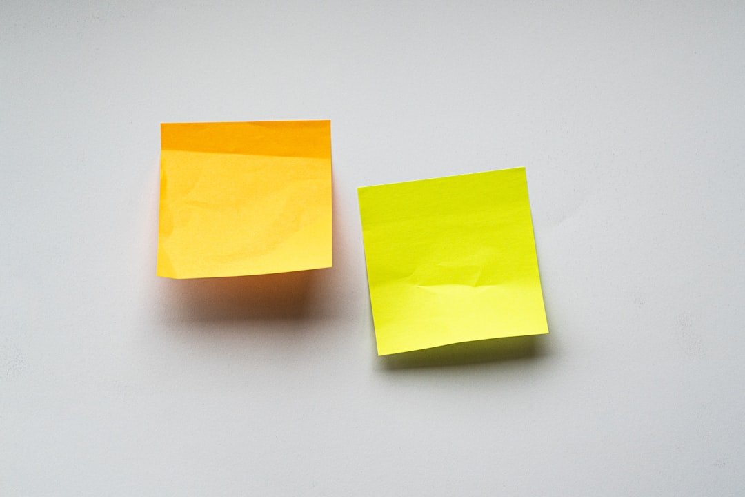 two sticky notes (post it notes) on a blank, white wall to use for your design project :)blank orange and green fluro sticky
