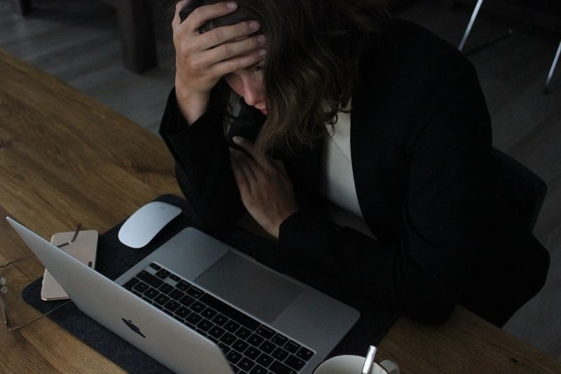 Missed deadline apology email in English: stressed worker at desk — 延誤截止日道歉信