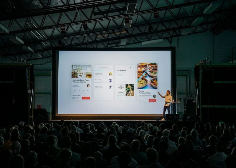 Speaker delivering a business presentation in English on stage