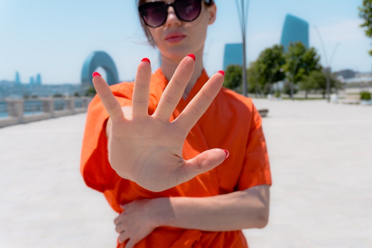 Woman raising hand to indicate a firm no — 禮貌拒絕英文 boundary
