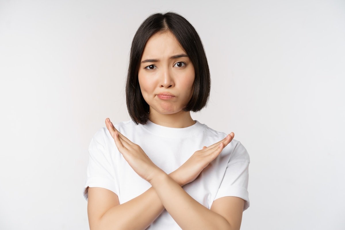 Asian woman crossing arms to refuse in English — 拒絕英文