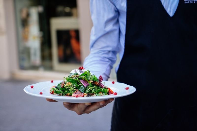 服務生英文 hostess showing diners to their table at a restaurant