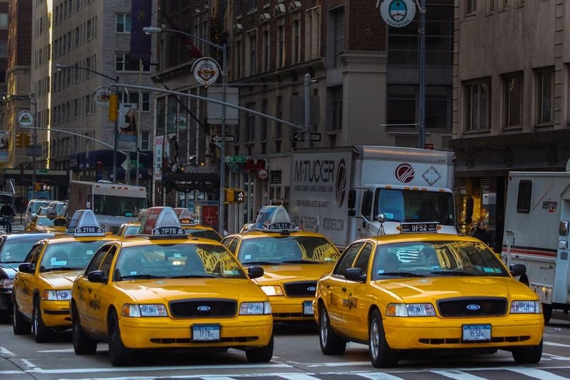 Yellow taxis on a city street — transport and taxi English 交通英文