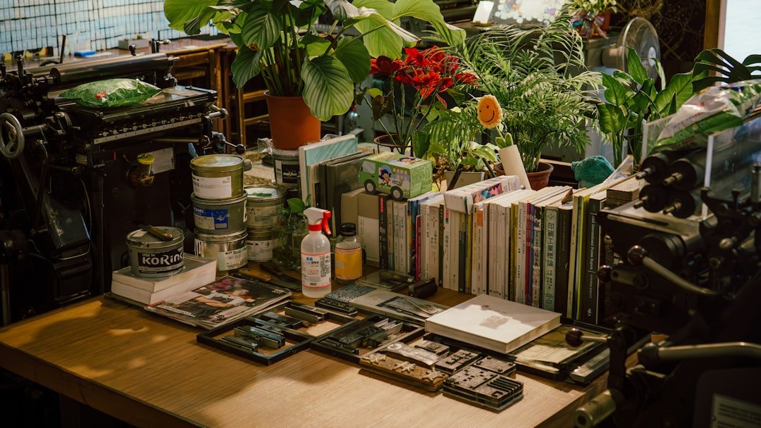 Inside a traditional printing workshop in Taichung, Taiwan, a wooden work table is cluttered with movable type sets, books on