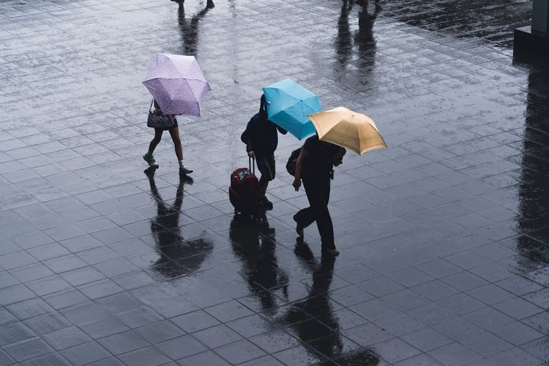 天氣英文 weather small talk three people holding umbrellas in the rain