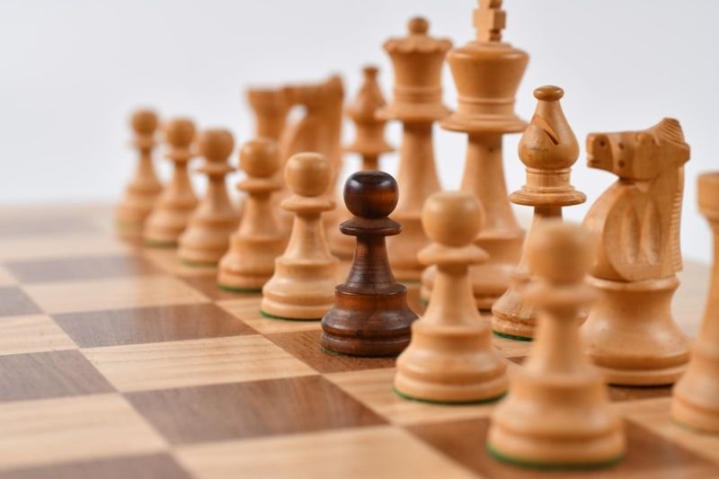 西洋棋盤上一顆深色棋子，象徵英文諺語中的智慧與判斷