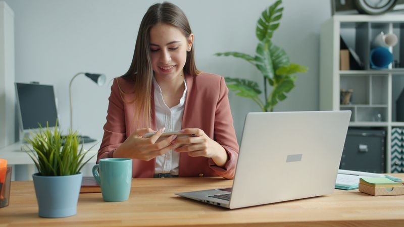 Businesswoman smiling while ending a phone English call on her smartphone
