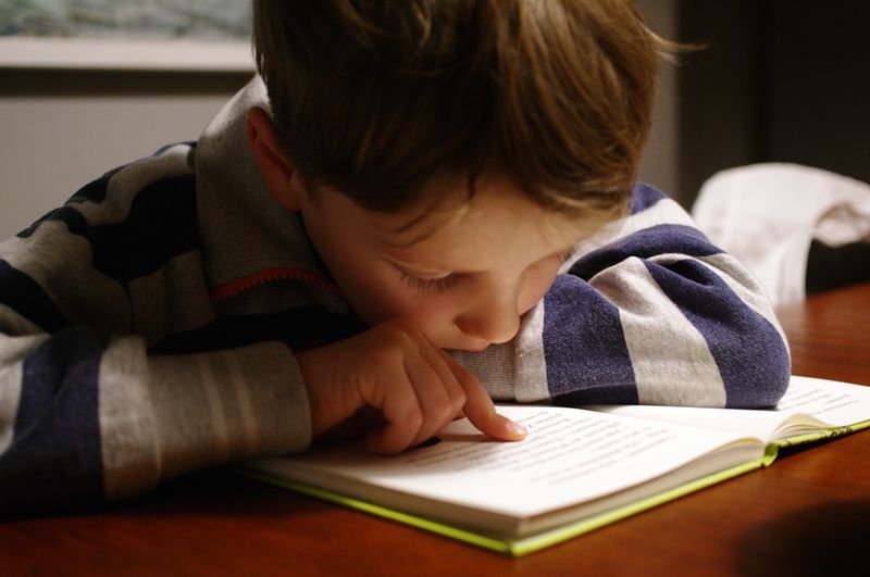 士林英文 child reading an English book during one-on-one tutoring