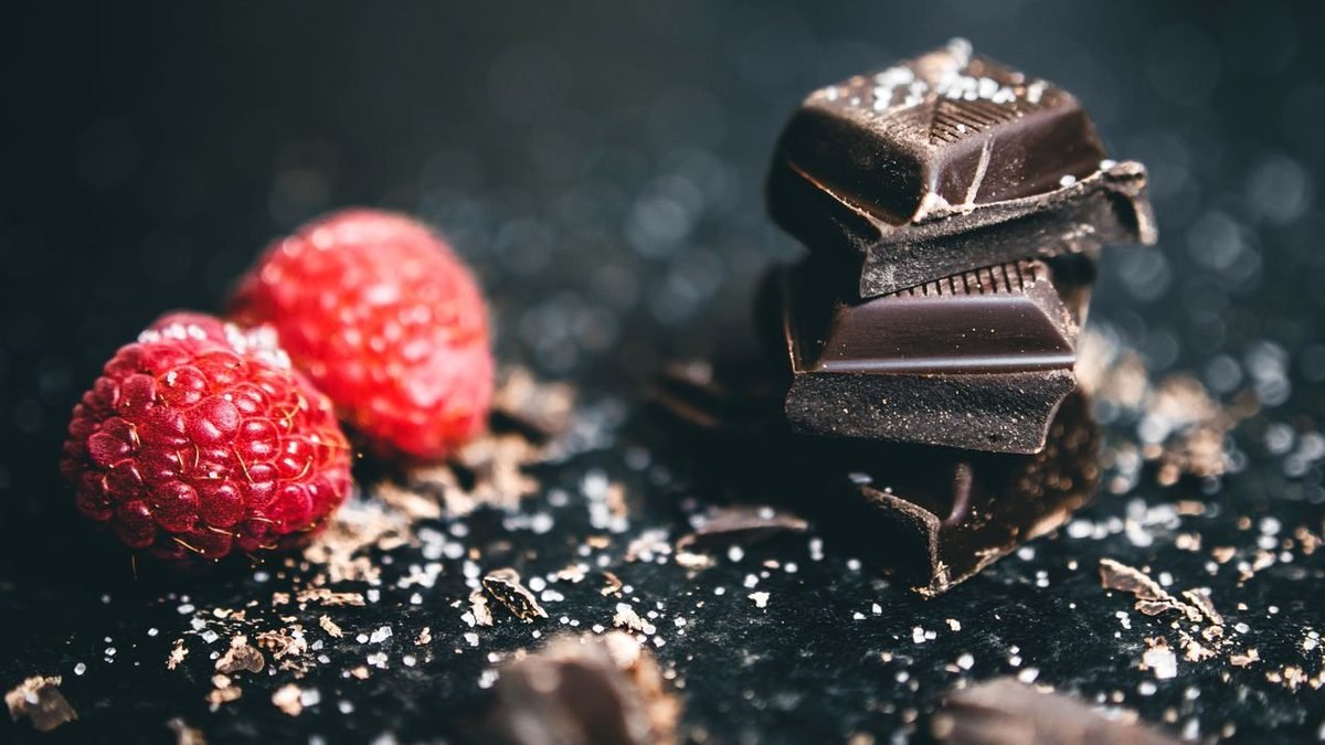 Pieces of dark chocolate with fresh raspberries