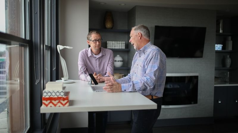 Two colleagues practising difficult phone English phrases in the office