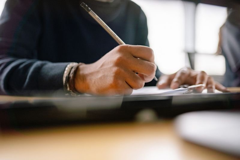 person writing in english correcting common concession grammar mistakes Taiwan learners