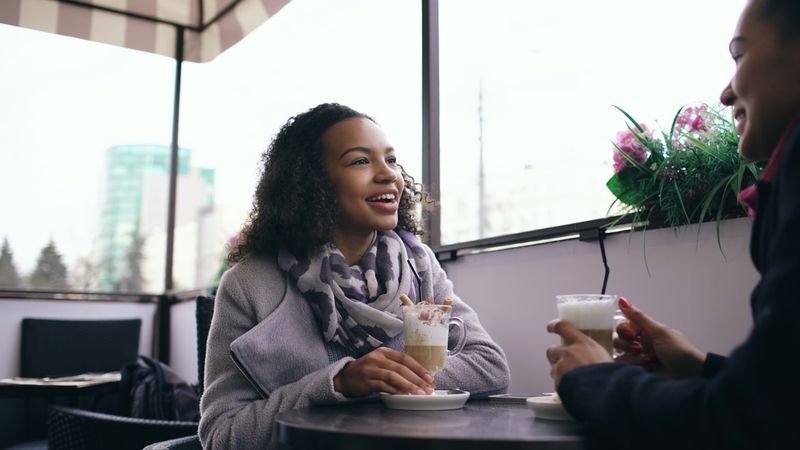 Two people chatting over coffee, using weak forms and connected speech naturally