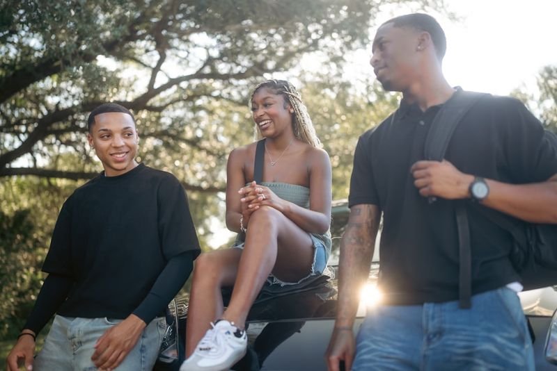 Three friends having a casual English conversation outdoors