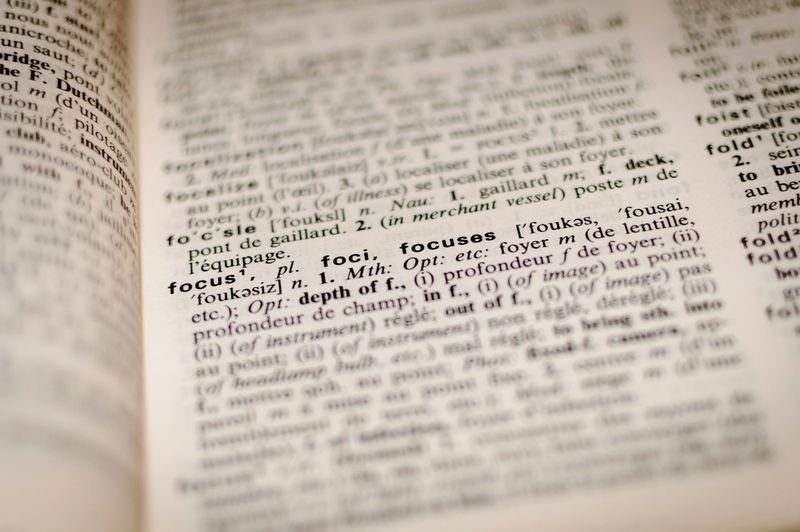 English grammar and punctuation reference book pages open on a desk