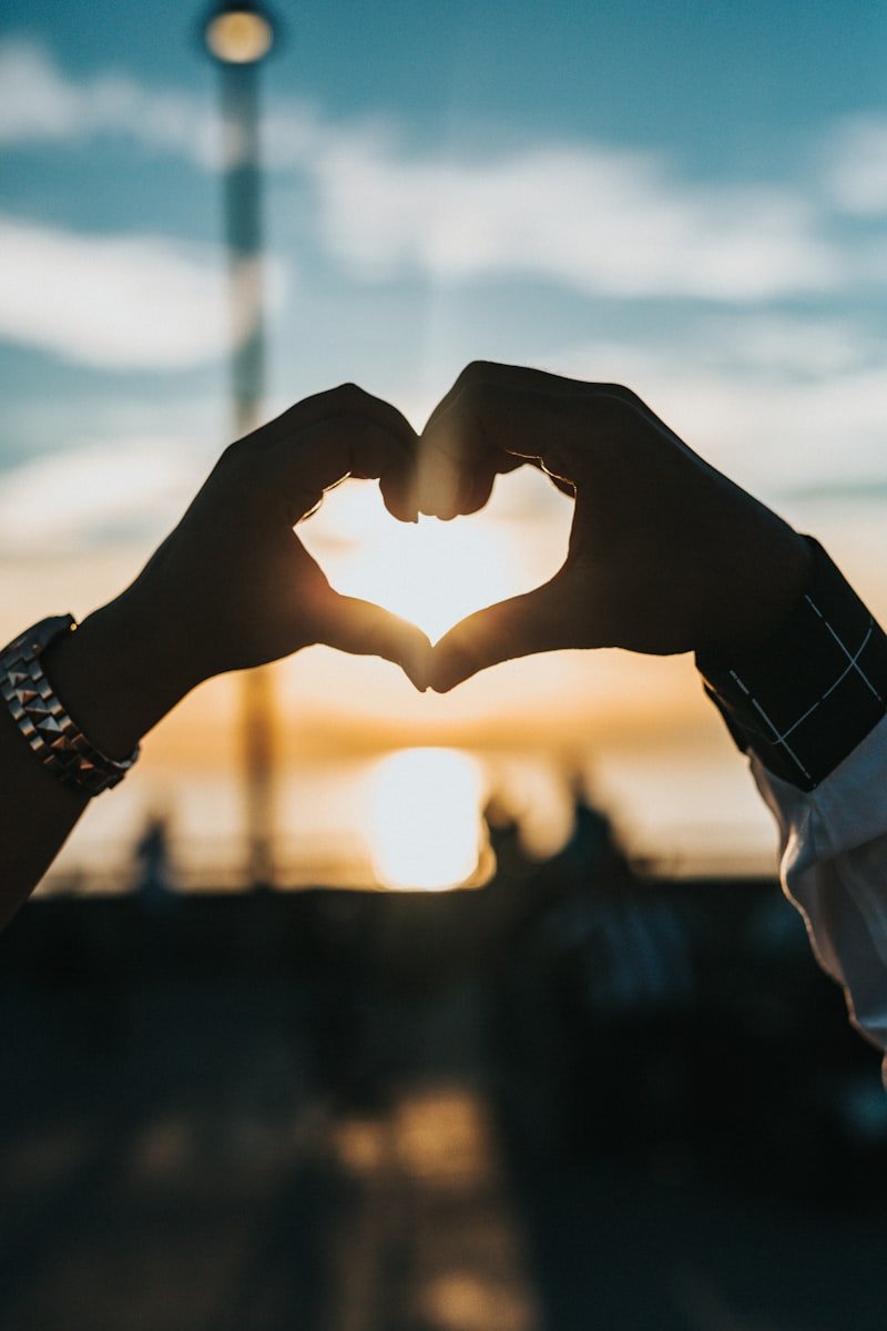 Pink heart in hands — fall head over heels English idiom about falling in love