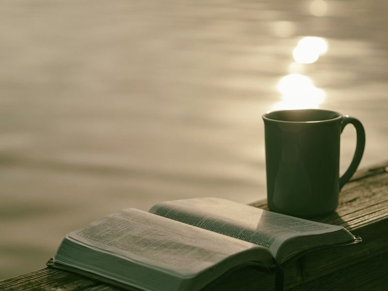 Open English book beside a coffee mug for weekend morning reading