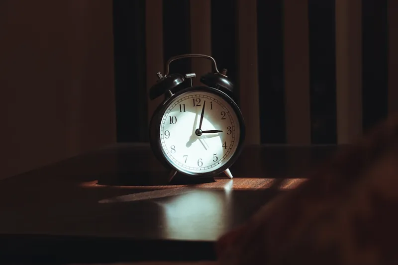 Person oversleeping alarm clock compound verb example
