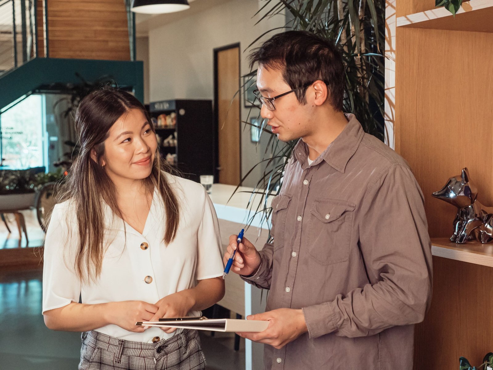 A man and a woman speaking in a building lobby