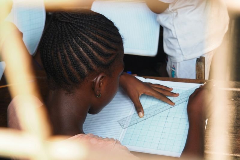 Student writing on paper during an ESL classroom writing game